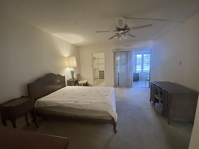 carpeted bedroom featuring a textured ceiling and ceiling fan