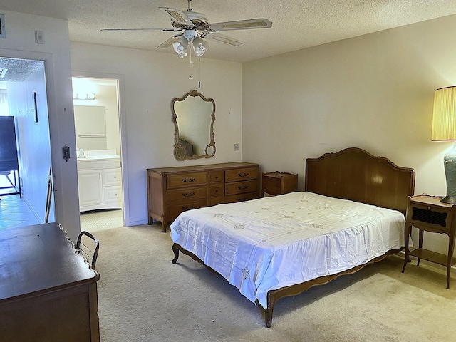 carpeted bedroom featuring ceiling fan, ensuite bath, and a textured ceiling