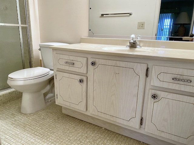 bathroom with tile patterned floors, vanity, toilet, and a shower with shower door