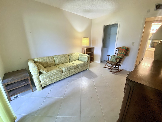 living room with light tile patterned flooring and a textured ceiling