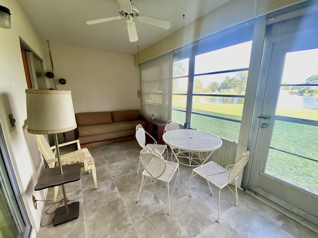 sunroom / solarium with a water view and ceiling fan