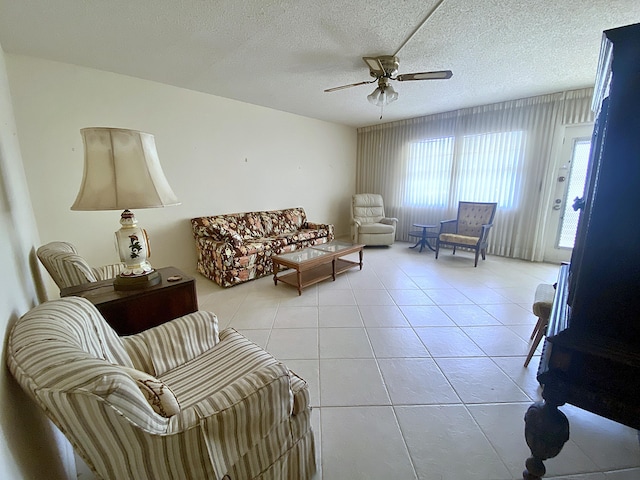 tiled living room with ceiling fan and a textured ceiling