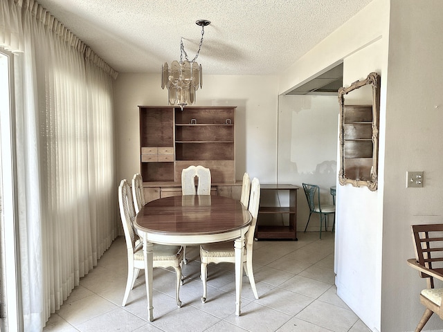 dining room featuring a textured ceiling, a chandelier, and light tile patterned flooring