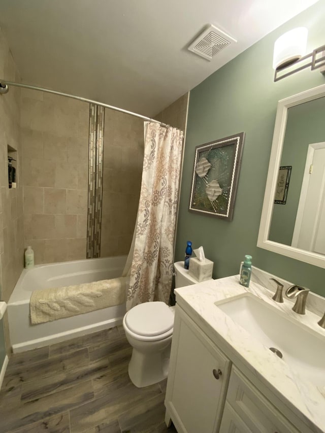 2086 SE Bisbee St, Port Saint Lucie, FL 34952 - bathroom with vanity, toilet, shower / bathtub combination with curtain, wood finished floors, and visible vents