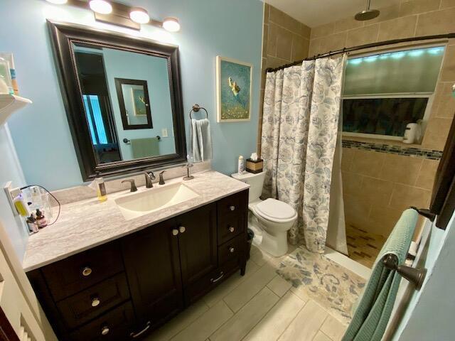 bathroom with vanity, curtained shower, and toilet