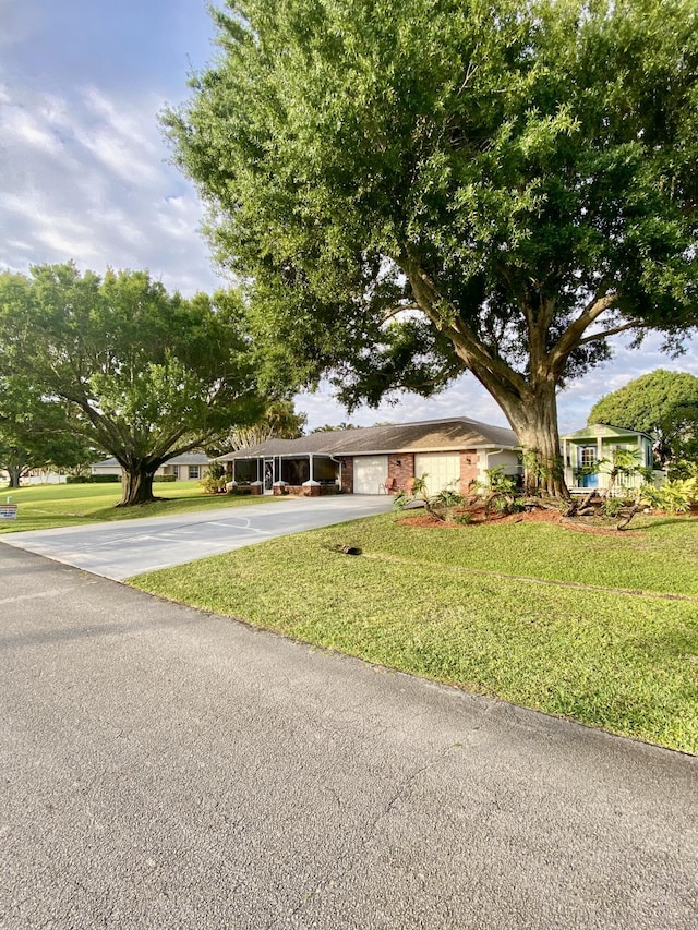 2086 SE Bisbee St, Port Saint Lucie, FL 34952 - ranch-style house featuring an attached garage, driveway, brick siding, and a front yard