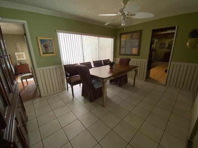 tiled dining space with crown molding, a textured ceiling, and ceiling fan