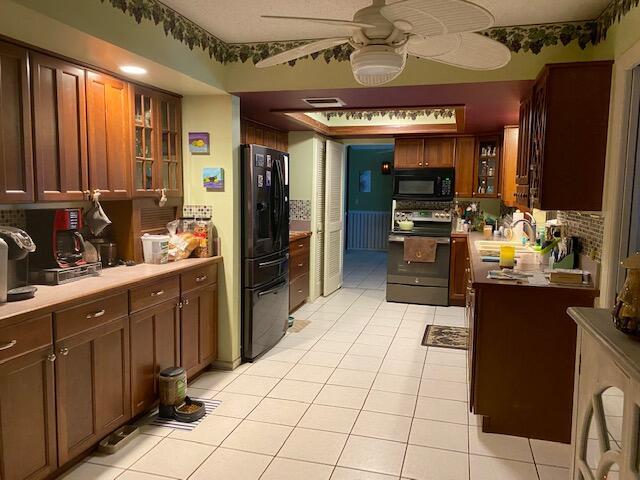 kitchen with sink, tasteful backsplash, light tile patterned floors, ceiling fan, and stainless steel appliances