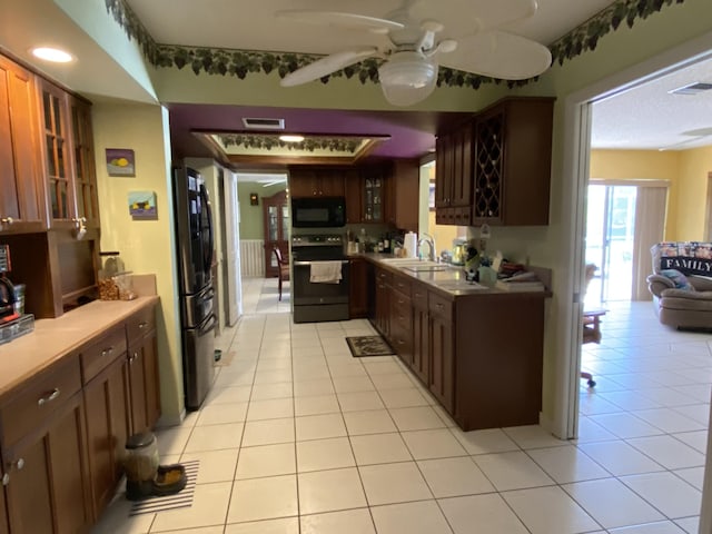 kitchen with visible vents, range with electric stovetop, freestanding refrigerator, black microwave, and glass insert cabinets