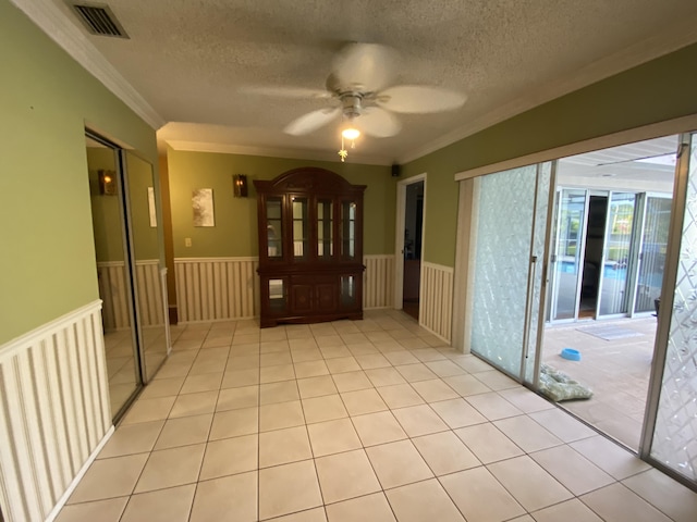 2086 SE Bisbee St, Port Saint Lucie, FL 34952 - foyer with a ceiling fan, a textured ceiling, visible vents, and a wainscoted wall