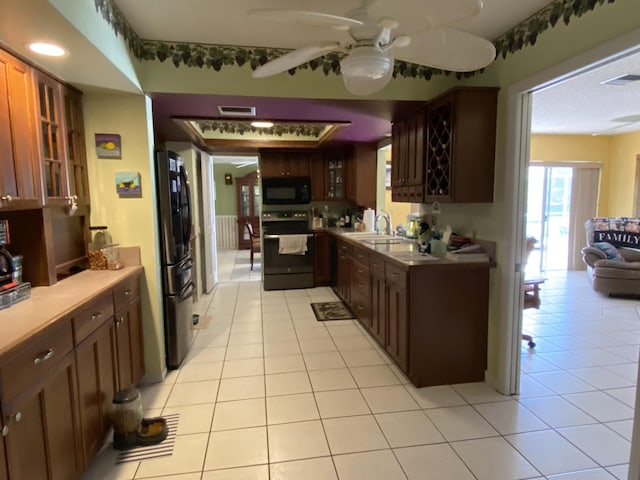 2086 SE Bisbee St, Port Saint Lucie, FL 34952 - kitchen featuring electric range, visible vents, black microwave, a sink, and freestanding refrigerator