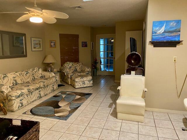 living room with light tile patterned floors and ceiling fan