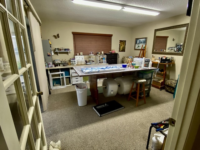 carpeted office featuring a textured ceiling