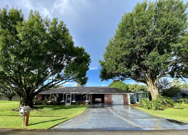 ranch-style home with a garage, brick siding, driveway, and a front lawn