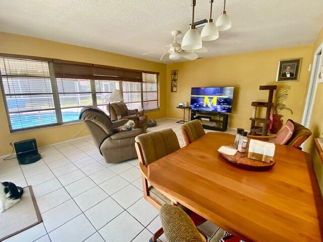 2086 SE Bisbee St, Port Saint Lucie, FL 34952 - dining space featuring a ceiling fan, a textured ceiling, and light tile patterned floors