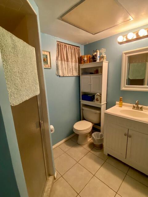 bathroom with vanity, tile patterned floors, toilet, and walk in shower