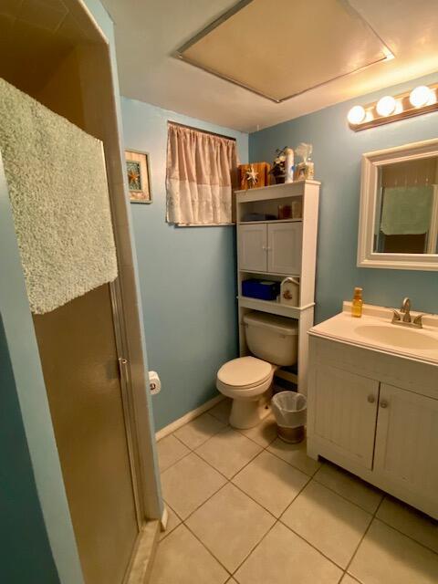 2086 SE Bisbee St, Port Saint Lucie, FL 34952 - bathroom with an enclosed shower, vanity, tile patterned flooring, and toilet