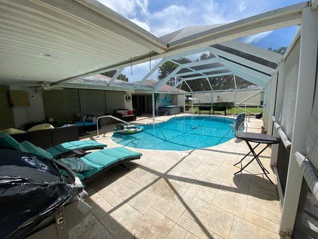 view of pool with a patio and glass enclosure