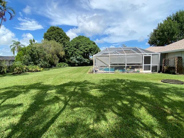 view of yard with an outdoor pool and glass enclosure