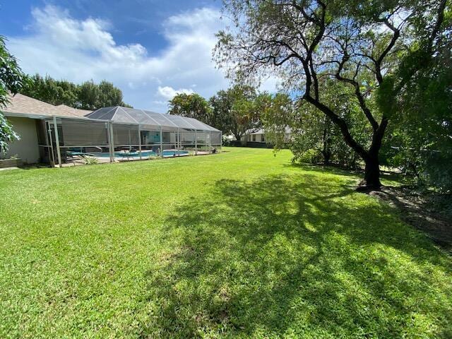 view of yard with a lanai and an outdoor pool