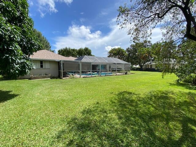 2086 SE Bisbee St, Port Saint Lucie, FL 34952 - view of yard featuring an outdoor pool and a lanai