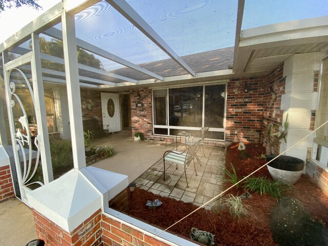 view of patio featuring a lanai