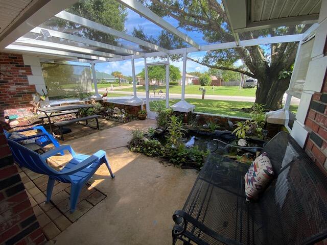 view of patio featuring a lanai