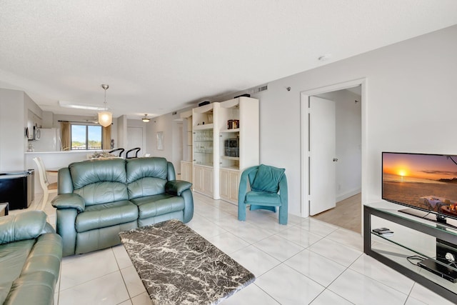 tiled living room featuring a textured ceiling