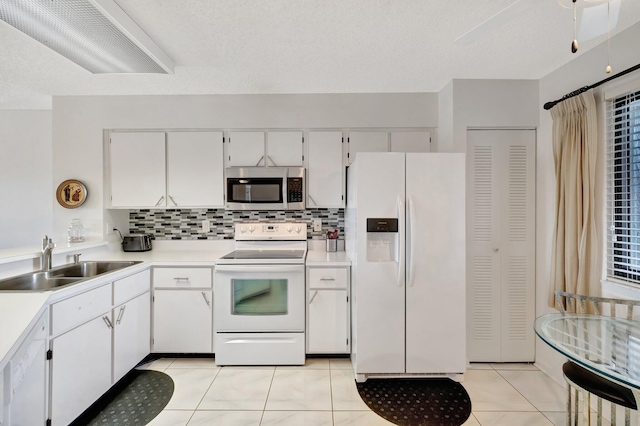 kitchen with white cabinetry, white appliances, sink, and backsplash