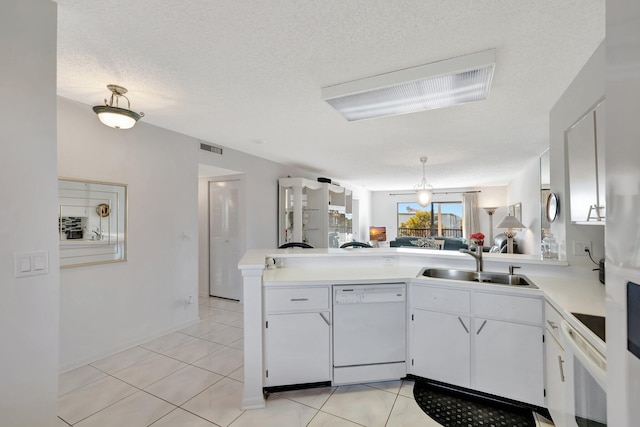 kitchen featuring sink, a textured ceiling, kitchen peninsula, white appliances, and white cabinets