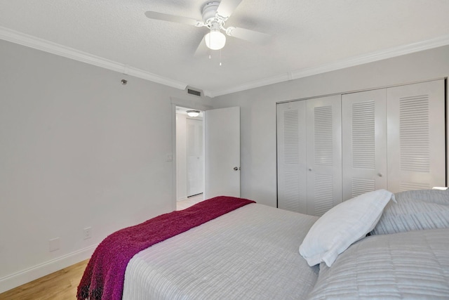 bedroom featuring crown molding, a textured ceiling, a closet, ceiling fan, and light hardwood / wood-style floors