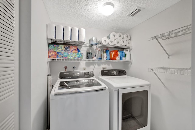 washroom featuring washer and dryer and a textured ceiling