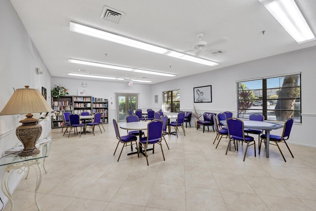 dining area with light tile patterned floors, a textured ceiling, and ceiling fan