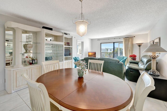 dining room featuring light tile patterned floors and a textured ceiling