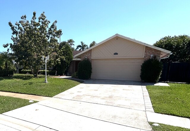 ranch-style house with a garage and a front lawn