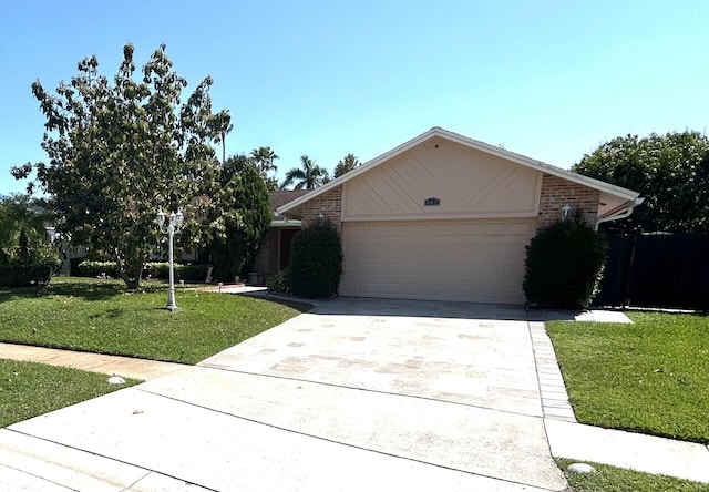 view of front of property with an attached garage, a front yard, concrete driveway, and brick siding