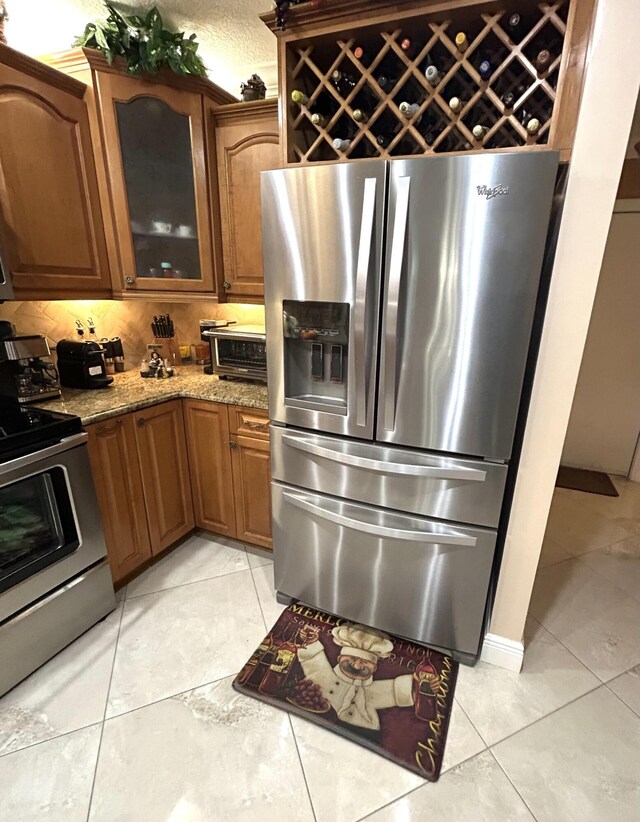 kitchen with light stone counters, ornamental molding, decorative light fixtures, and sink