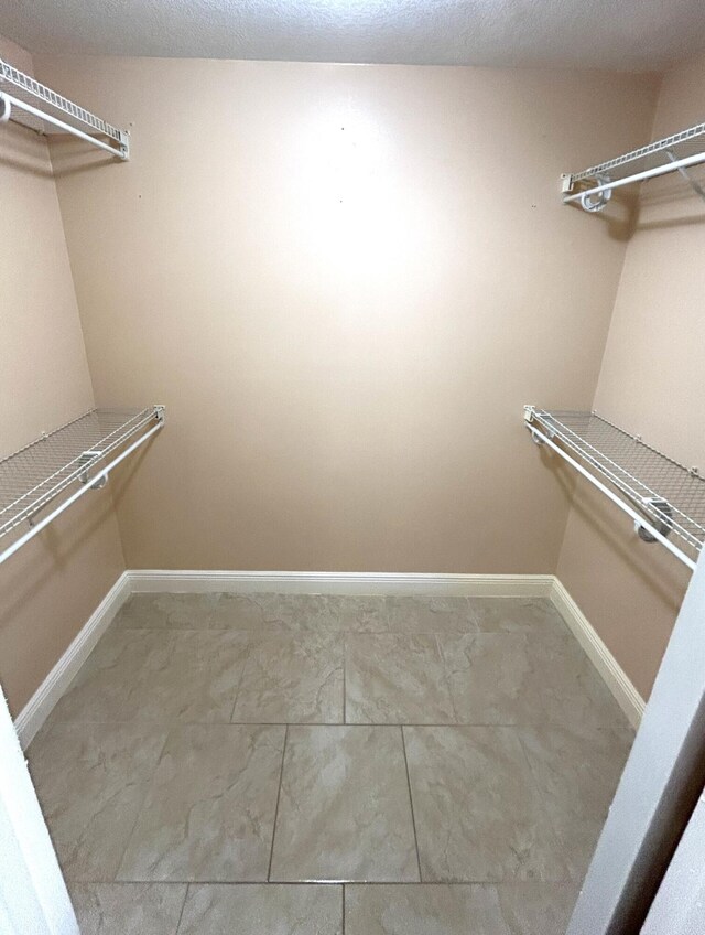 bathroom with toilet, a shower with shower door, tile walls, a textured ceiling, and vanity