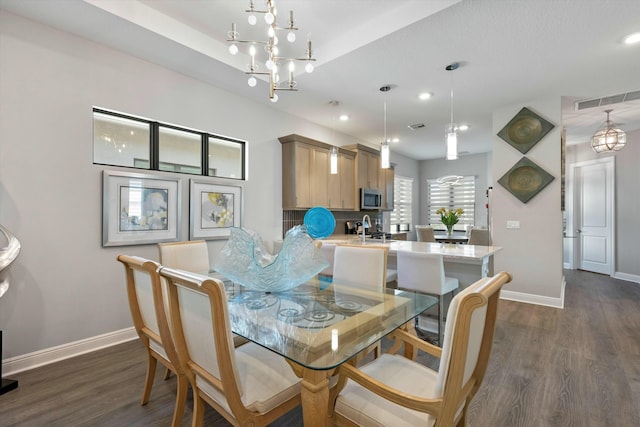 dining area featuring sink, a chandelier, and dark hardwood / wood-style flooring