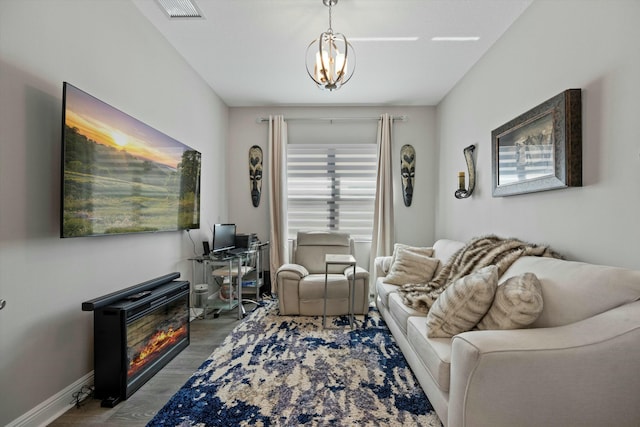 living room featuring an inviting chandelier and wood-type flooring