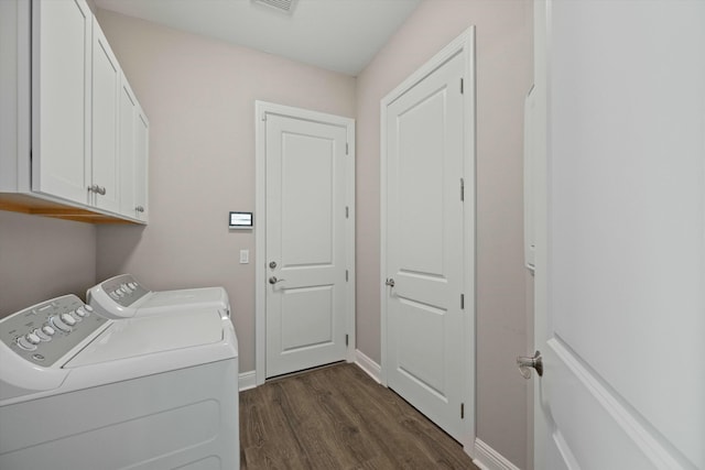 laundry room featuring separate washer and dryer, dark hardwood / wood-style floors, and cabinets