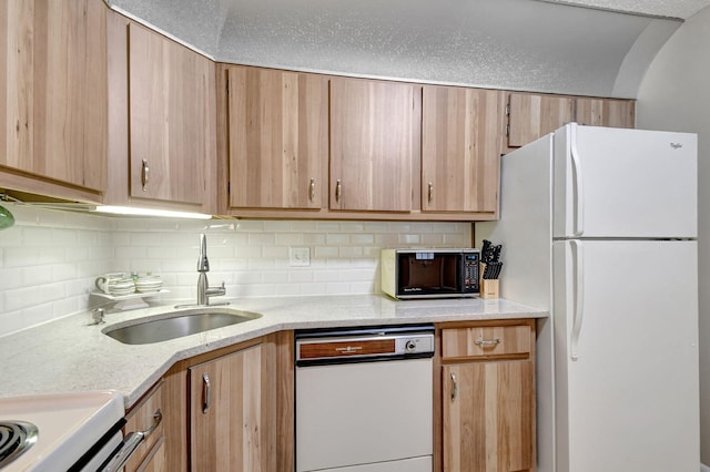 kitchen featuring light brown cabinets, a sink, tasteful backsplash, white appliances, and light stone countertops