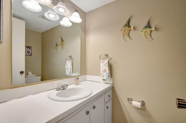 half bath featuring vanity, a notable chandelier, toilet, and visible vents