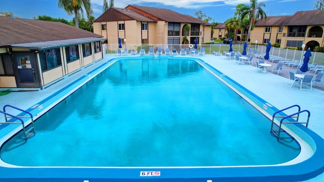 community pool featuring a patio and fence