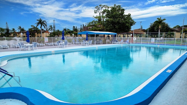 pool with a patio area and fence