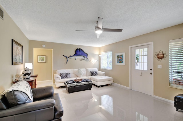 tiled living room with visible vents, baseboards, a textured ceiling, and a ceiling fan