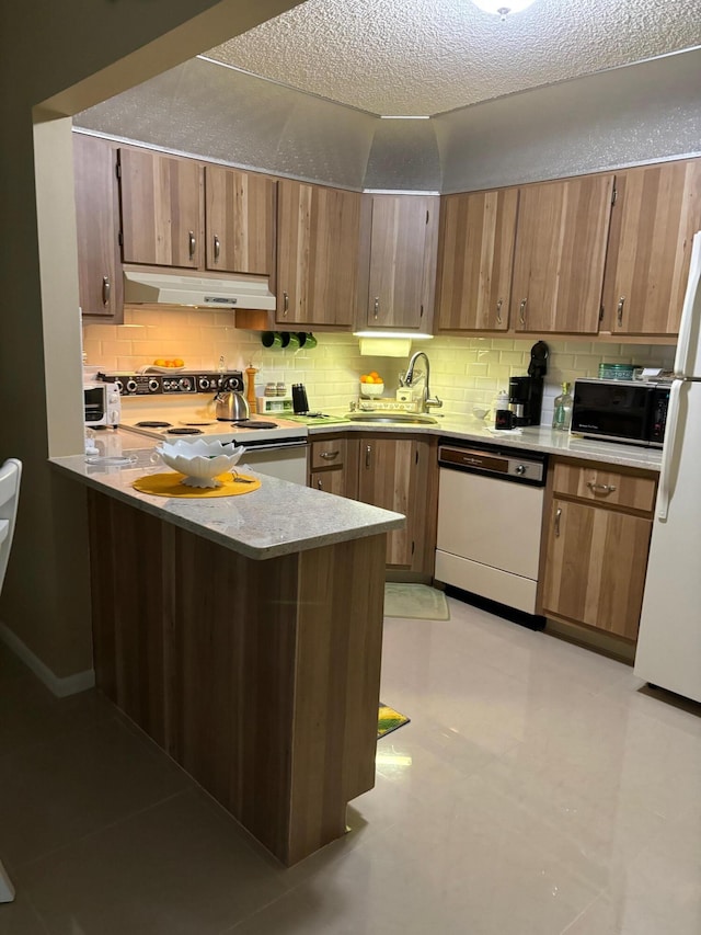 kitchen with sink, white appliances, backsplash, a textured ceiling, and kitchen peninsula