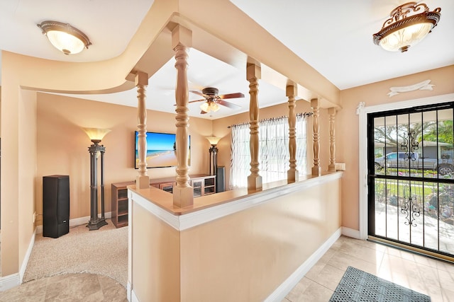 interior space with light tile patterned flooring, plenty of natural light, and kitchen peninsula