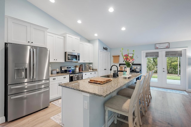 kitchen featuring sink, a center island with sink, white cabinets, and appliances with stainless steel finishes