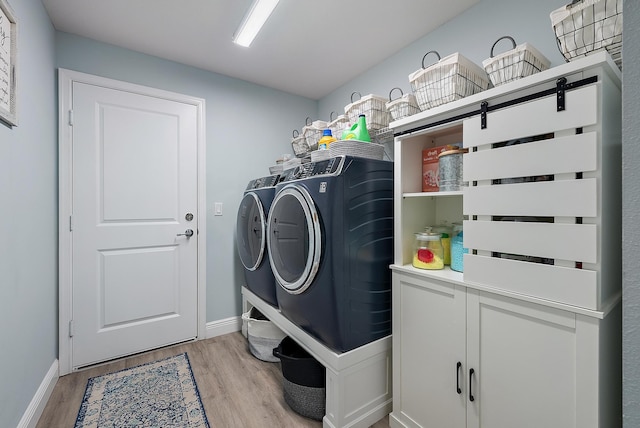 clothes washing area featuring independent washer and dryer and light wood-type flooring